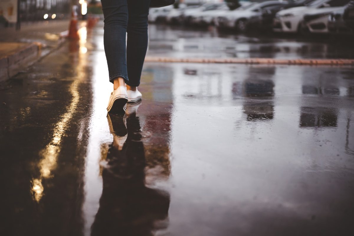 Unidentified woman walking down a wet treet