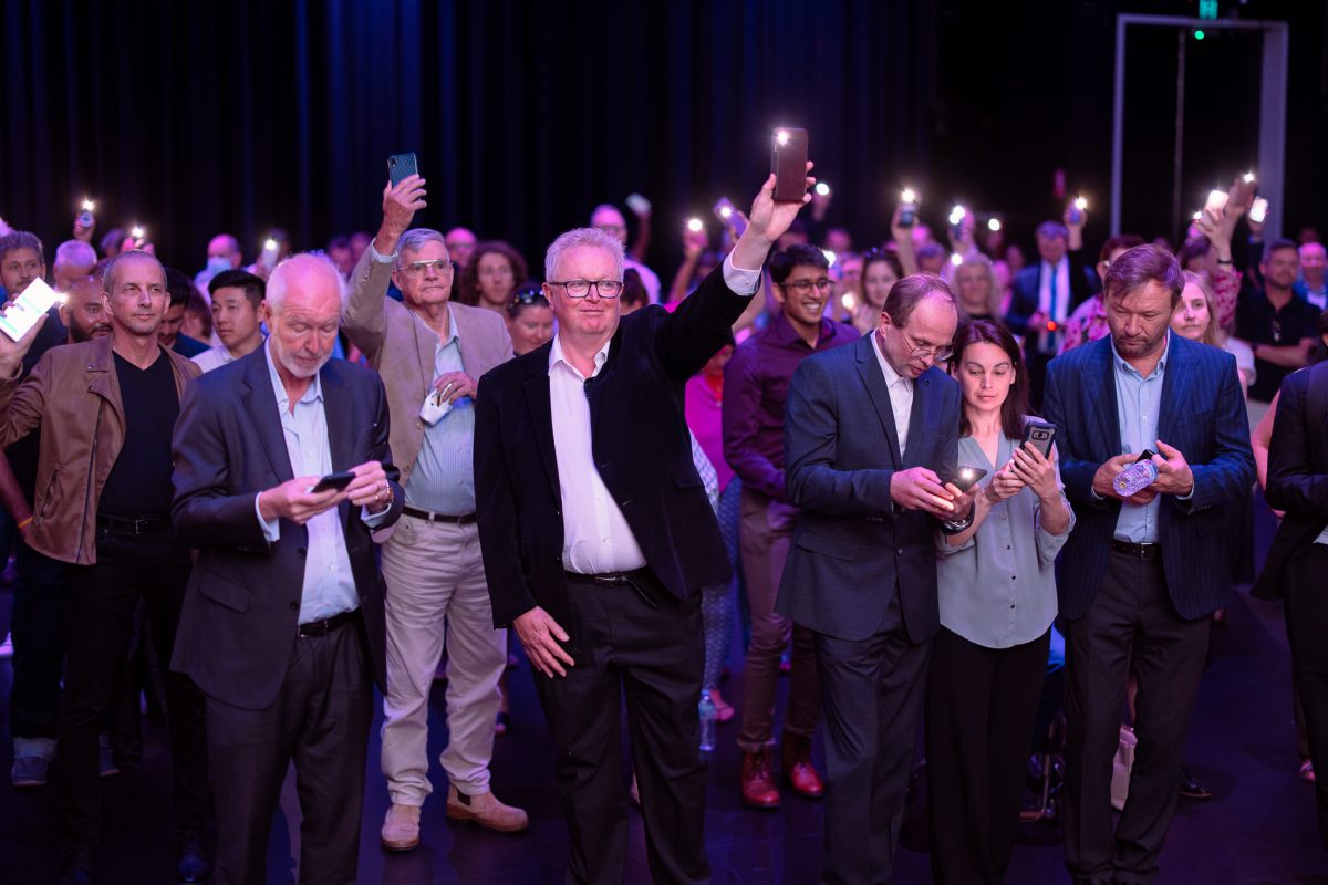 Crowd of people at CBRIN's annual Innovation Showcase hold up their phones