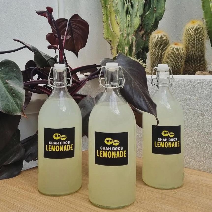 Three bottles of Lemonade with labels that say 'Shah Bros Lemonade'
