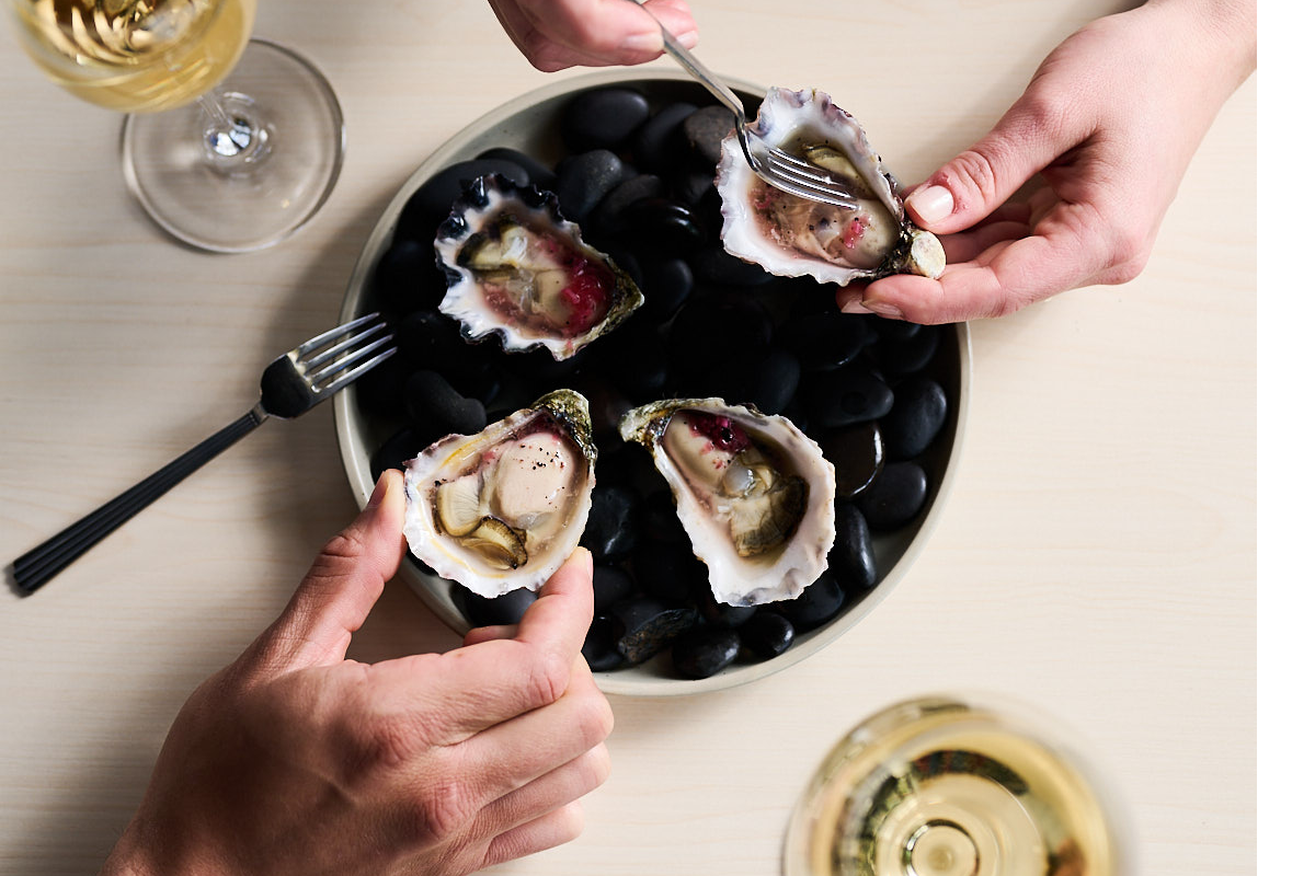 plate of oysters with glasses of wine