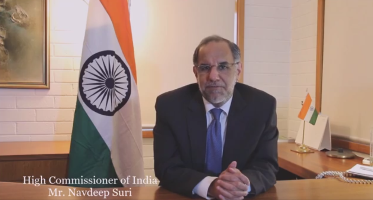 man sitting at desk with Indian flag