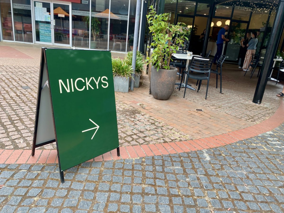 Green A-frame sign reading NICKYS in bold white print.