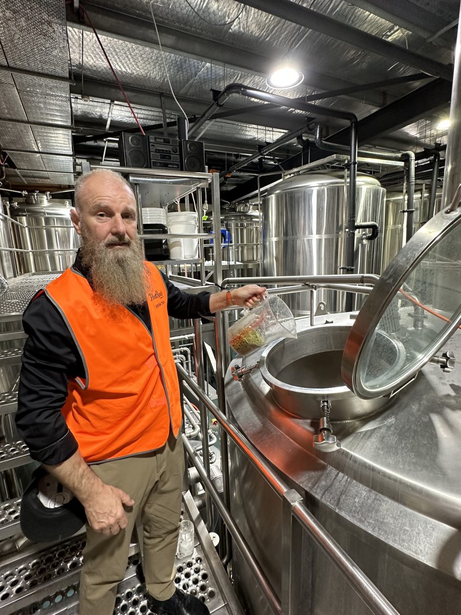 Peter standing next to one of the company's brewing vats.