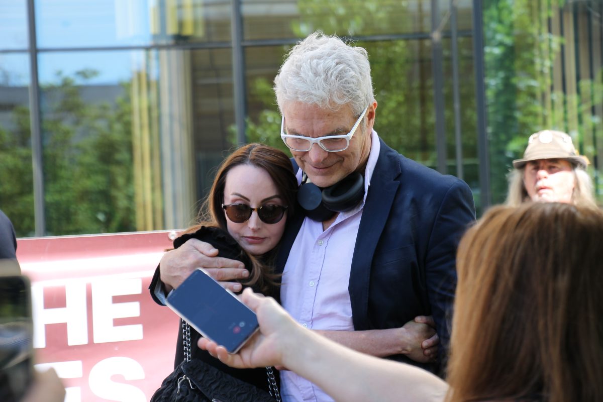 man hugging a woman outside court