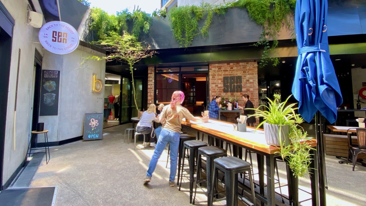 Courtyard with a waitperson setting a long hightop table