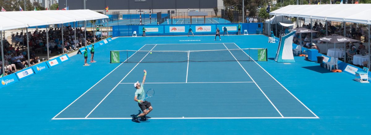 A tennis player in the middle of a serve