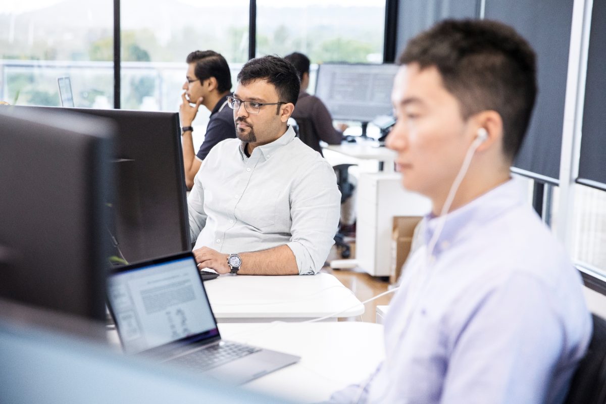 Diverse group of people on laptops in office working