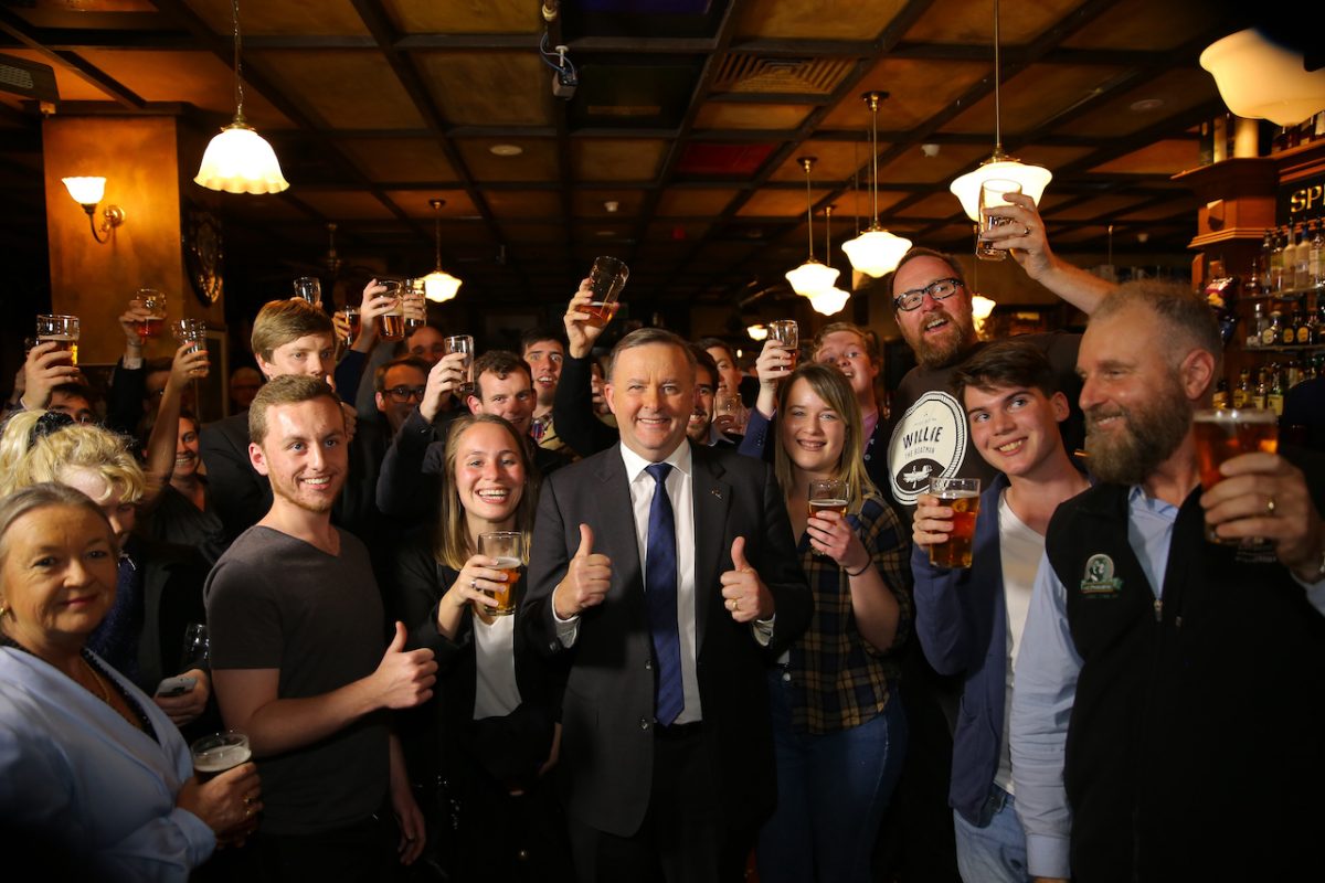 PM Anthony Albanese raising a glass with pub staff