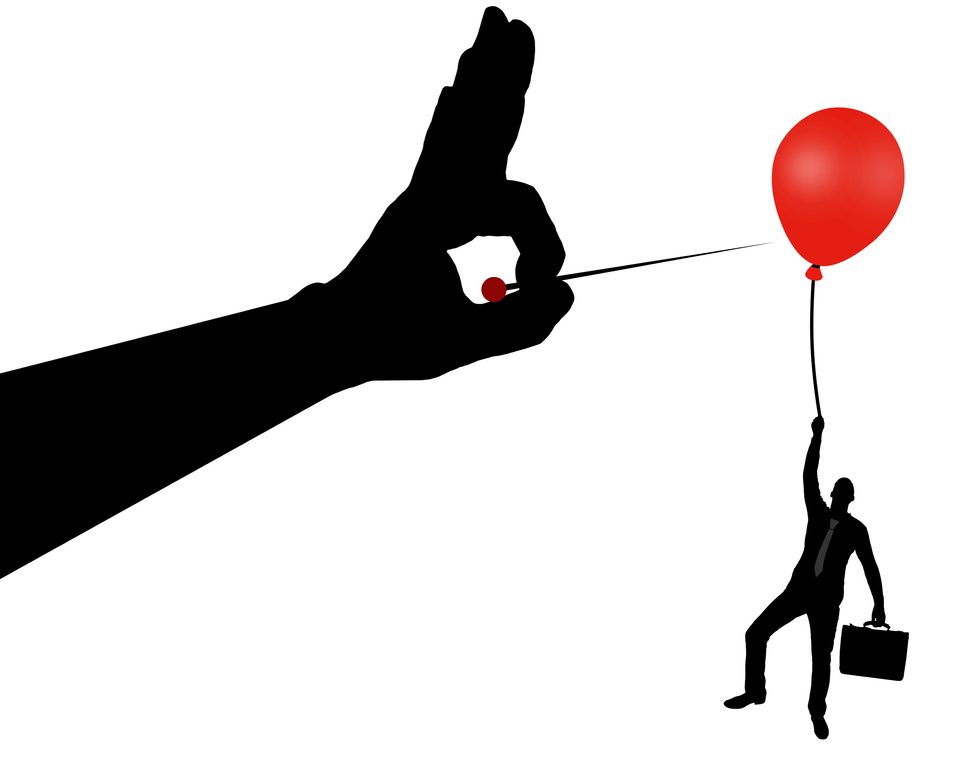 man pricking balloon with a pin