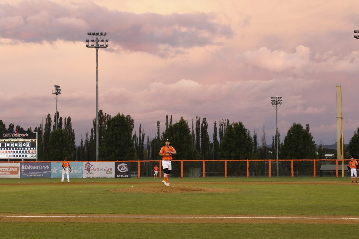 A baseball player standing on the field by himself