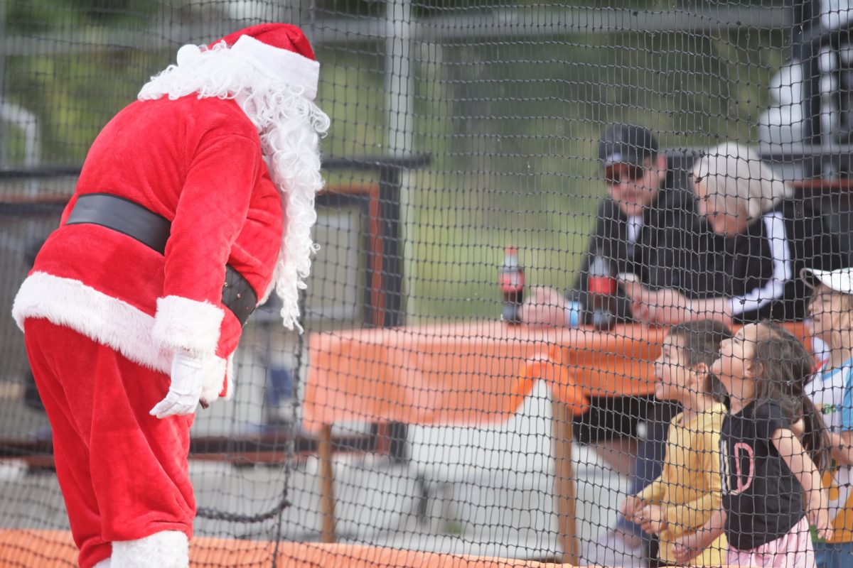 Santa greets children at a Canberra Cavalry baseba;; game