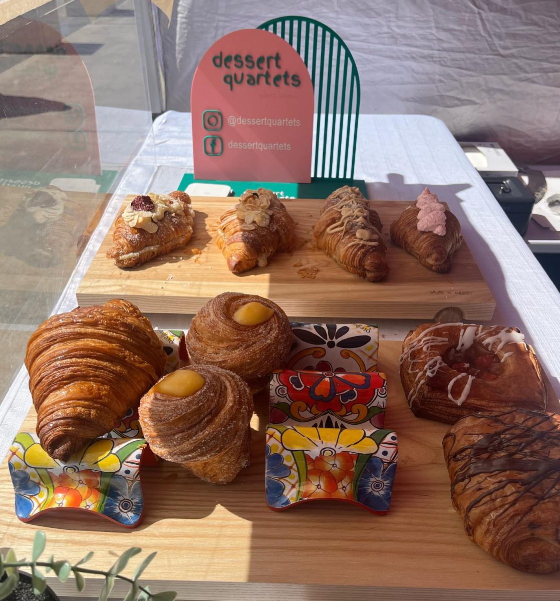 selection of pastries on wooden boards with Dessert Quartets logo in background.