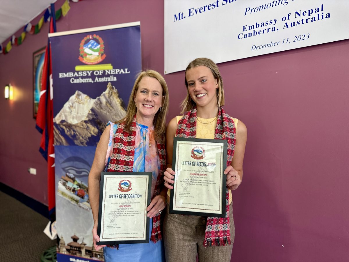 wo women holding Everest climb certificates
