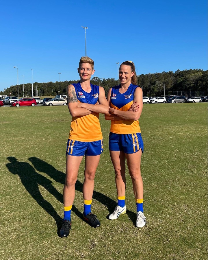 two female AFL payers with arms folded