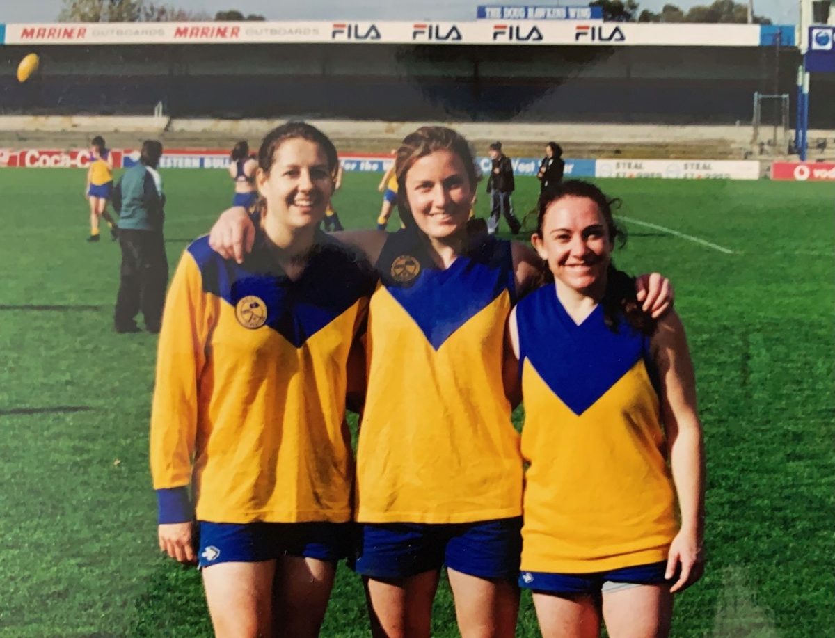 three female AFL players posing for the camera