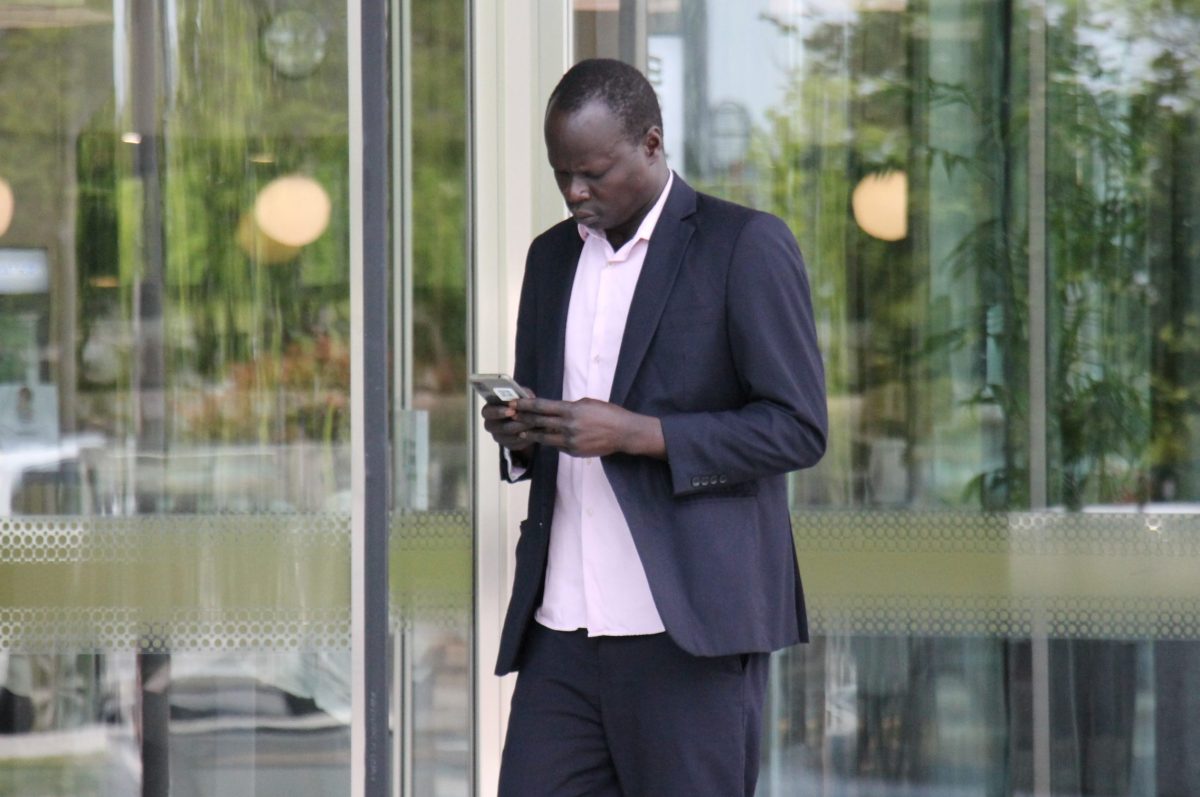 man outside court looking at his phone