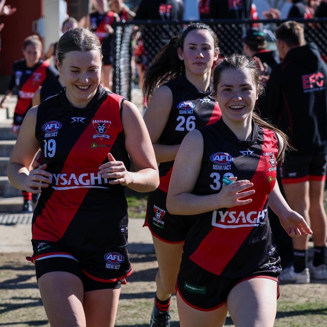 femals AFL players running onto the field