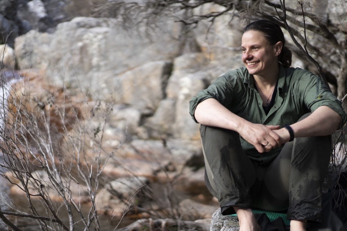 Woman smiling and sitting down in bushland