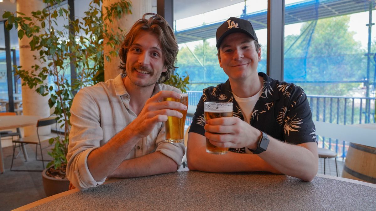 Ned and Josh holding pints of beer