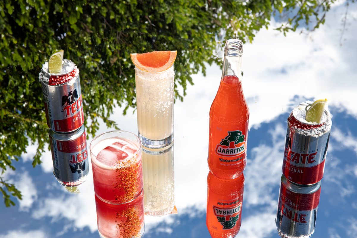 drinks in cans and glasses on mirror surface showing cloudy sky