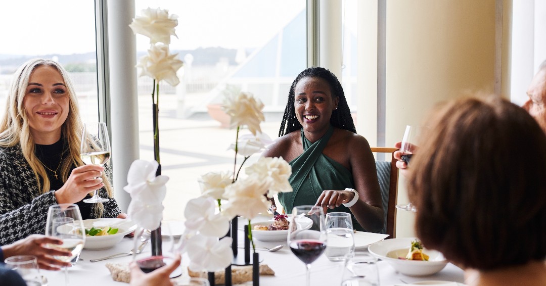 Three people sitting around a table, having high tea