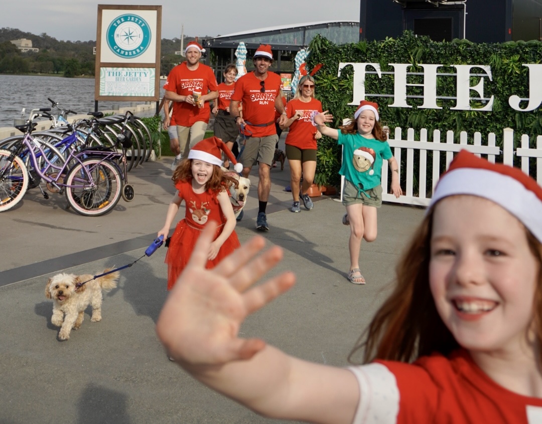 People in Santa hats and red t-shirts at the Jetty in Canberra for Running for Resilience Santa Run