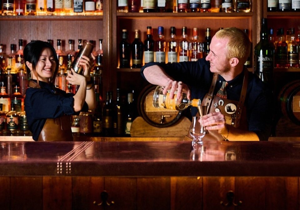 bartenders making cocktails behind Molly bar