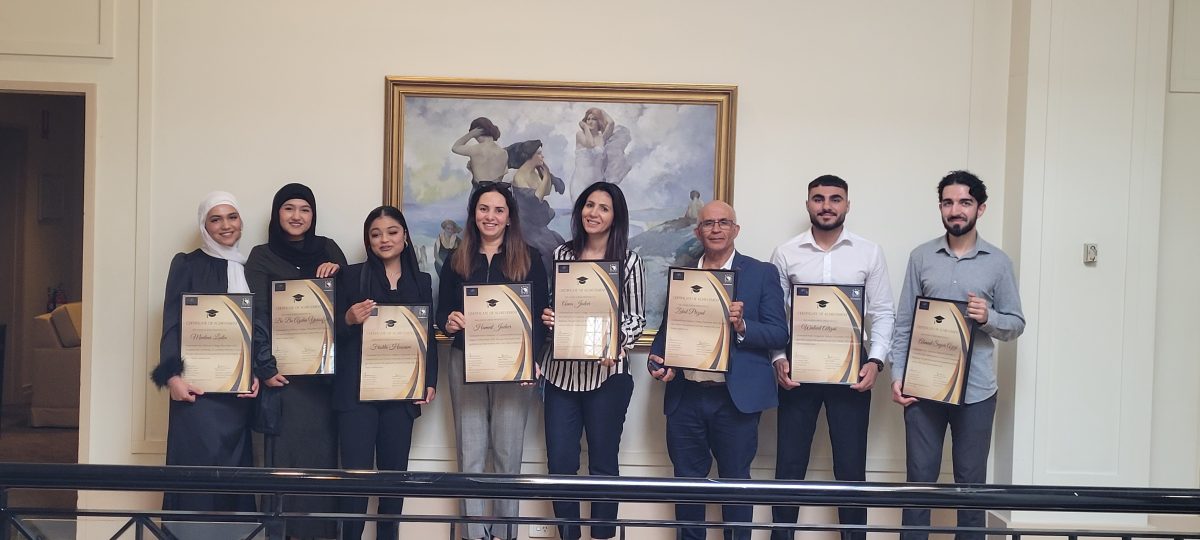 Eight people holding up certificates 