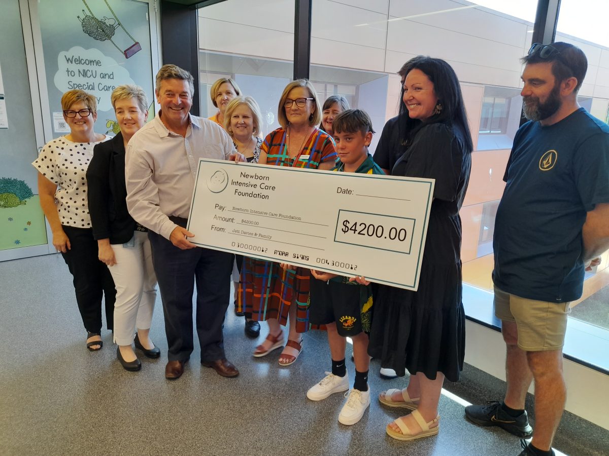 Family in hospital presenting novelty cheque