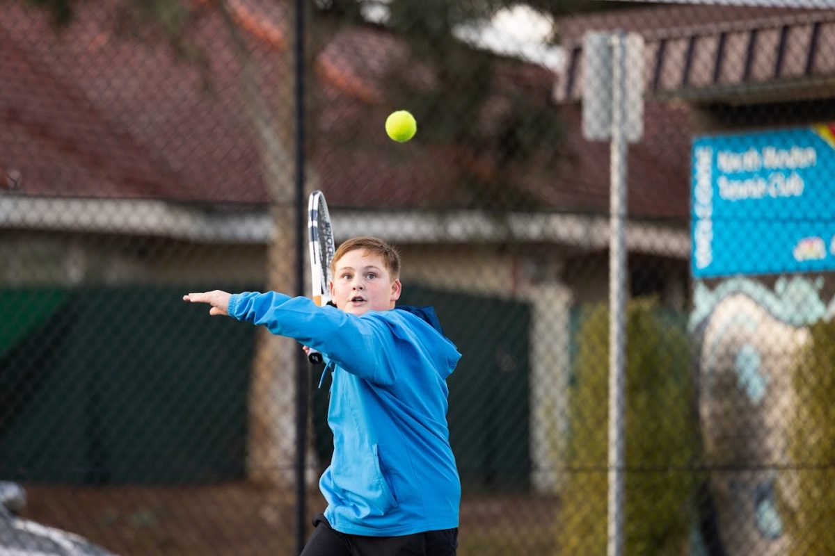 A young boy plays tennis at the all abilities hub in Woden