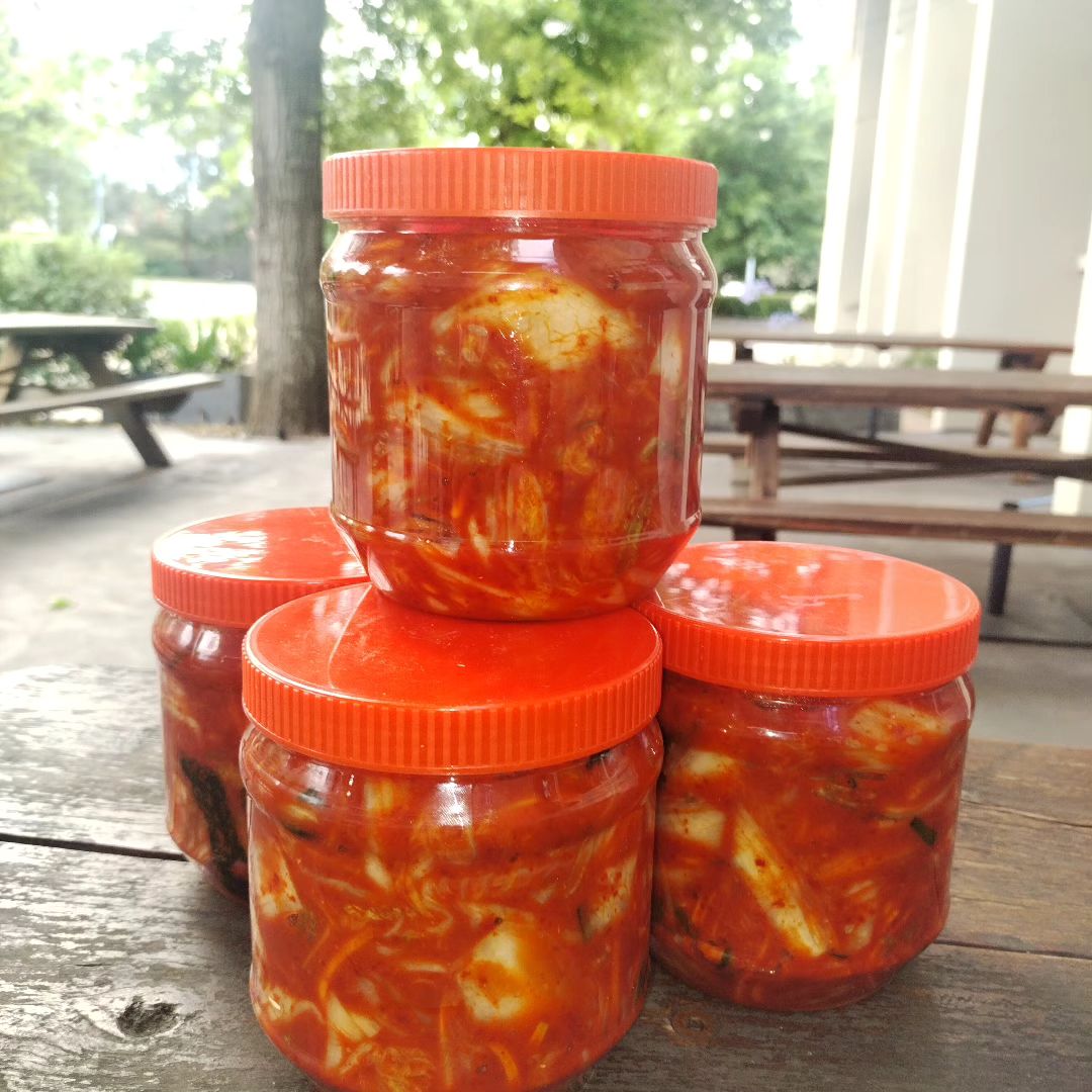 Four tubs of spicy looking kimchi.