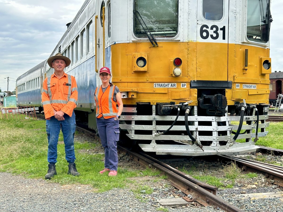 man and woman standing next to a train