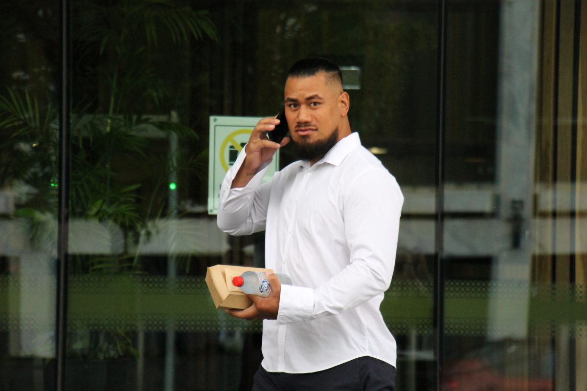 man outside court on his phone