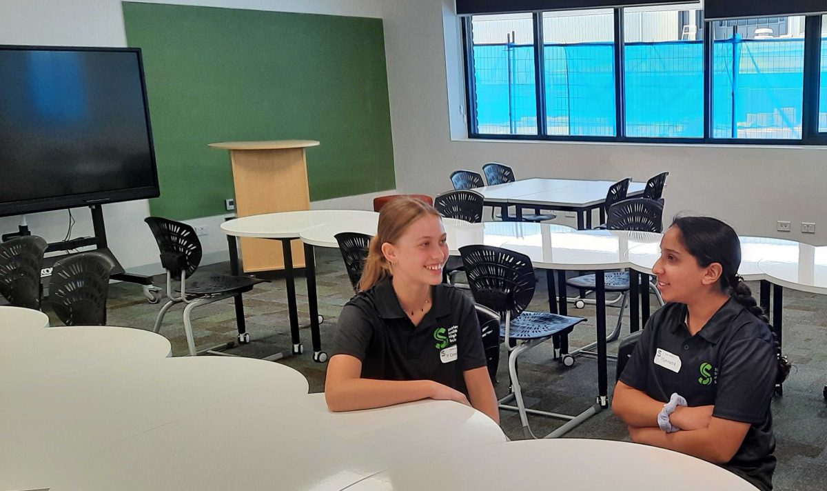 two high school students sitting in a classroom