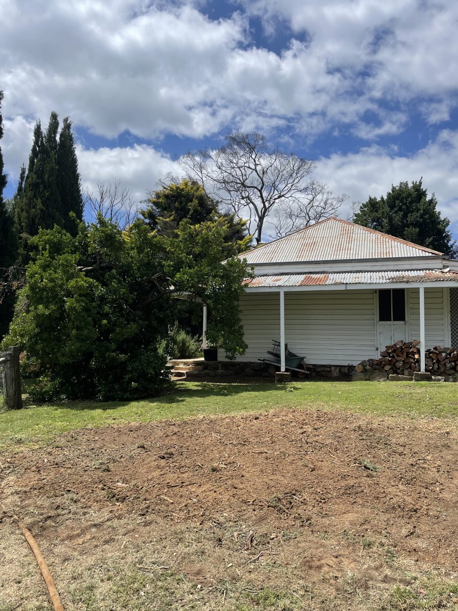 Pile of dirt outside old cottage where tree used to be