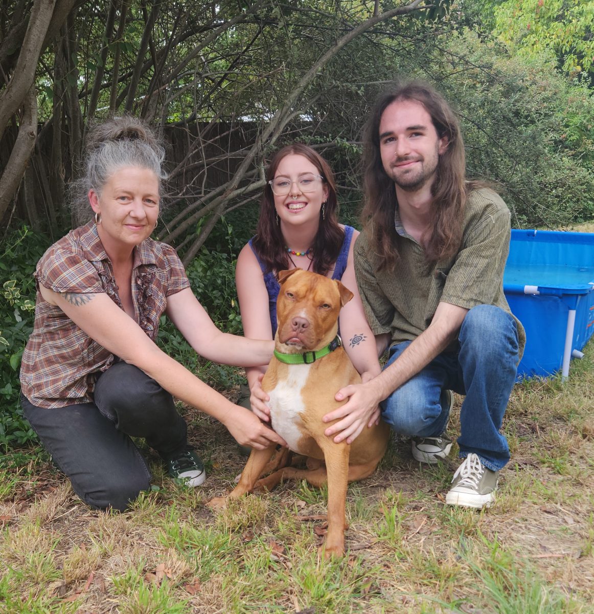 Two women and a man with brown dog