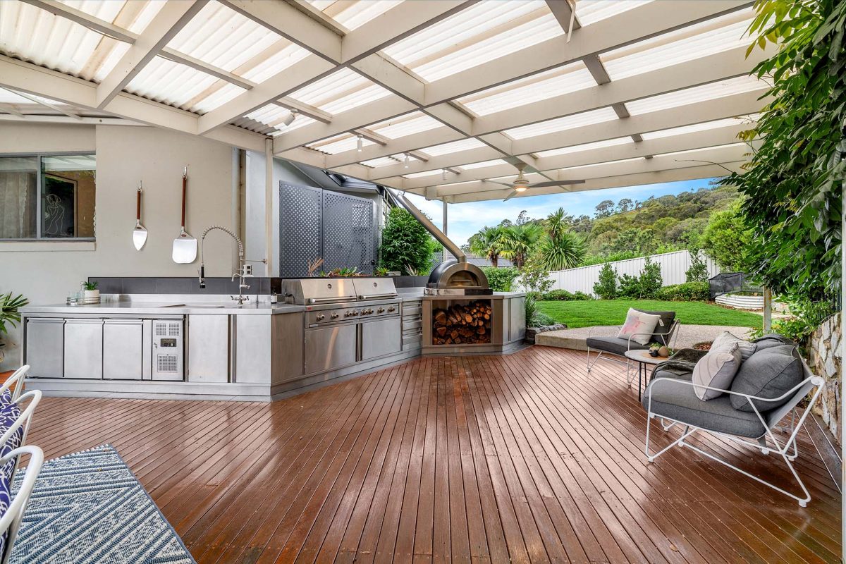 Covered outdoor area at Number 21 Lincoln Close in Chapman featuring a pizza oven, twin barbecues and a full outdoor kitchen with sink and built-in fridge