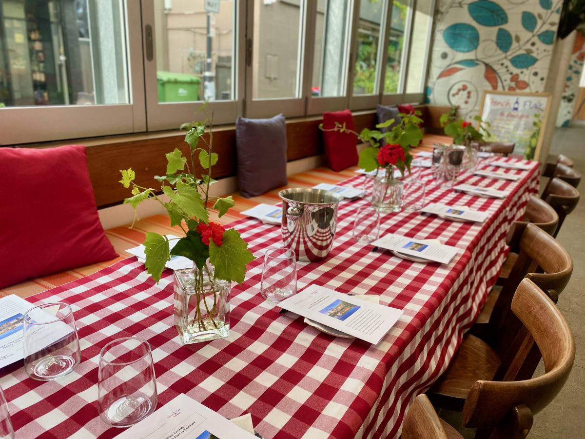 Table set with wine glasses, flowers and a red gingham tablecloth