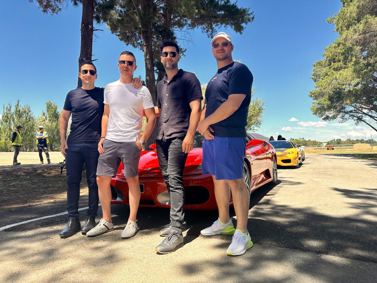 four men with a red sports car