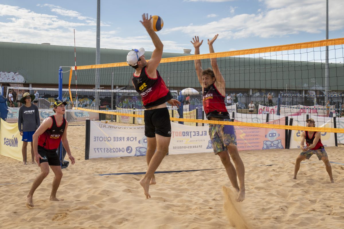 young men playing beach volleyball