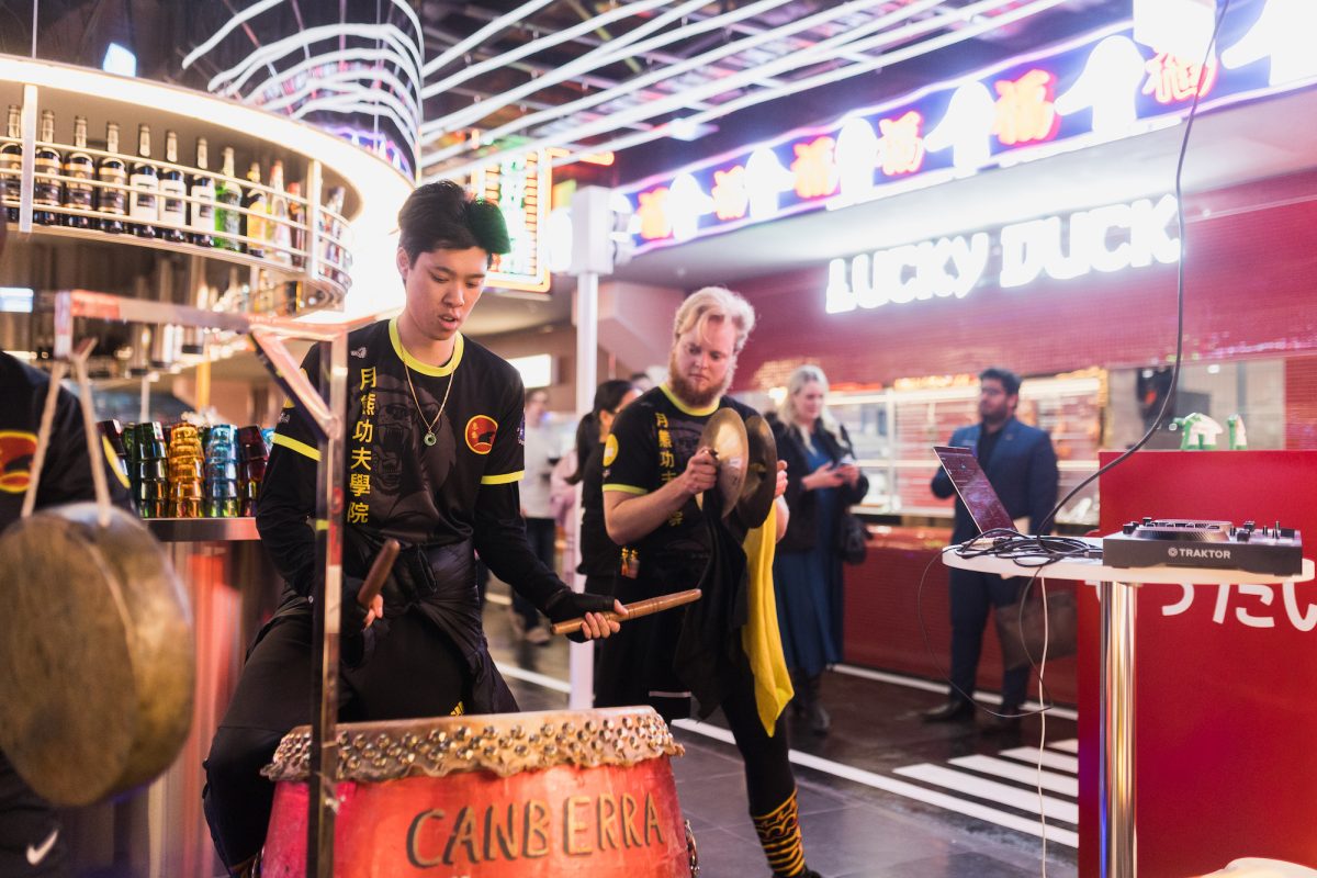 People playing traditional drums inside food court.