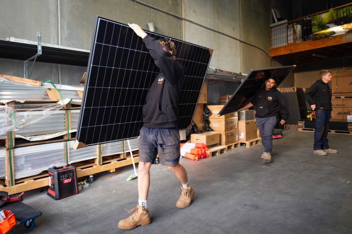 people carrying solar panels