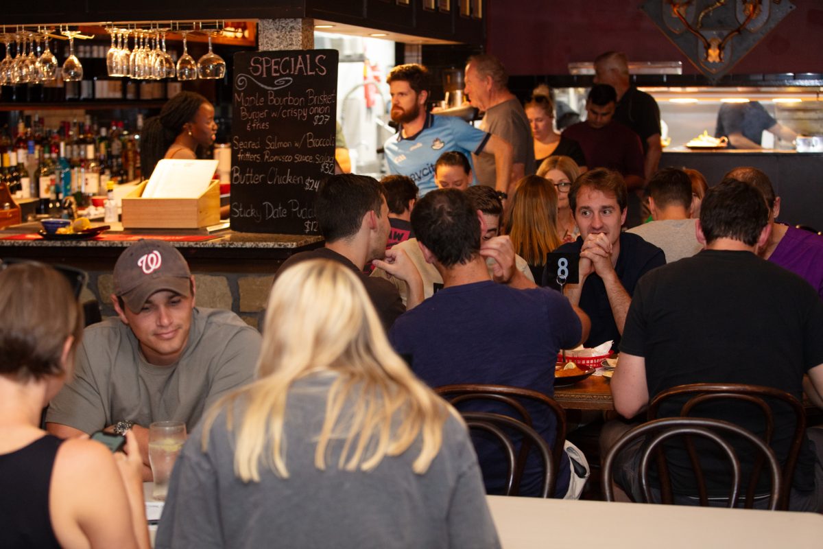 people sitting at tables in a pub