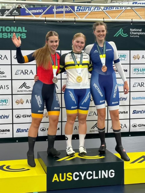 three female cyclists on a podium