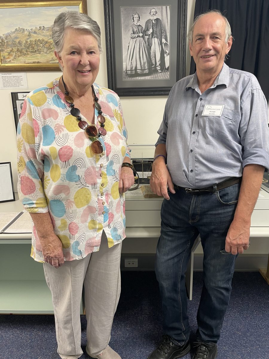 Woman and man in front of old portraits