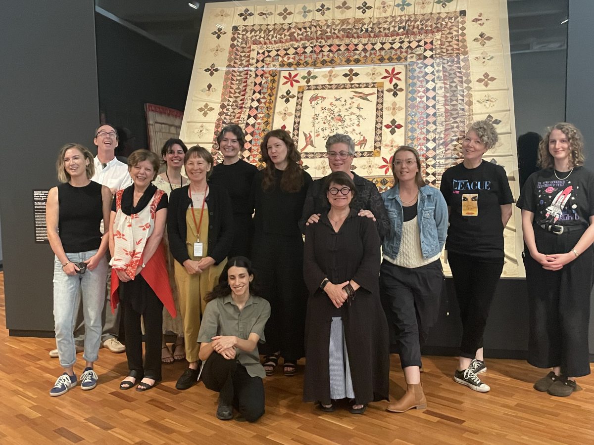 Group of people in front of quilt