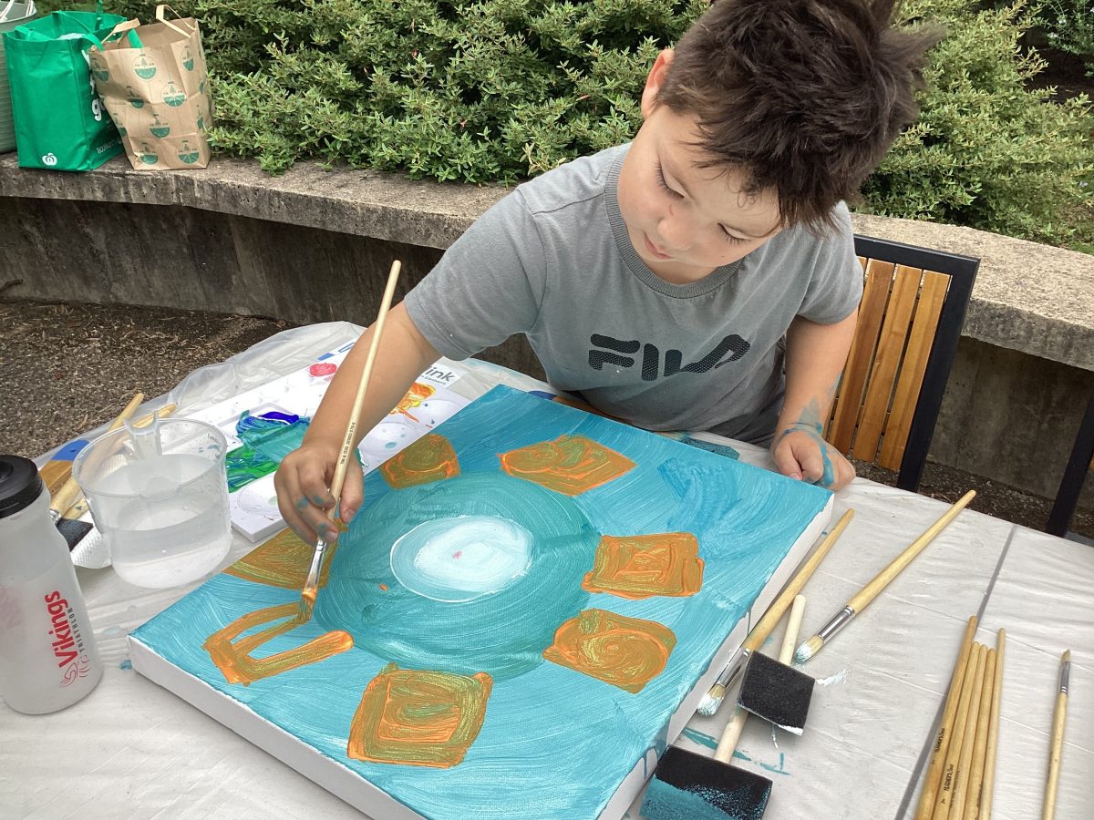 boy painting while sitting down