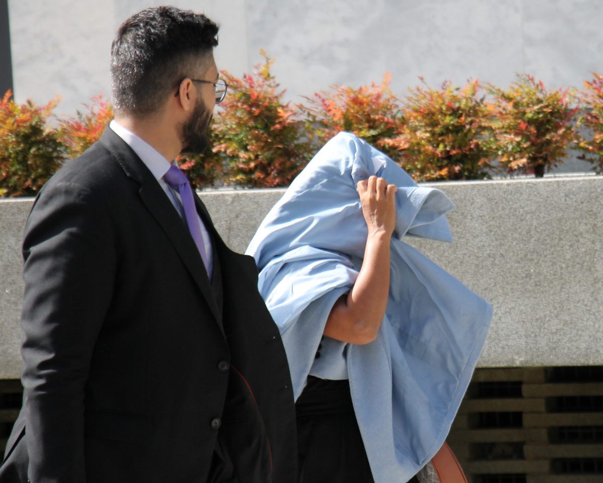 woman hiding her face outside court