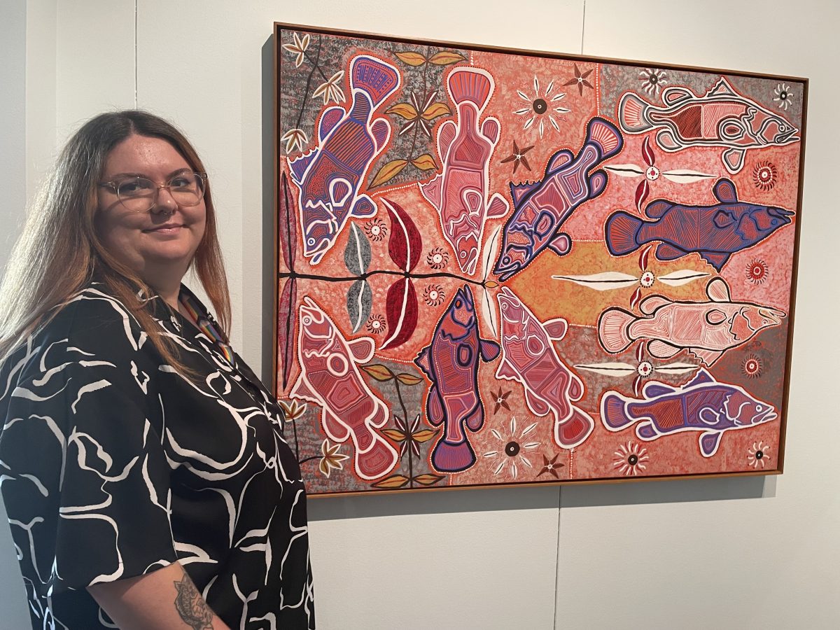 Woman standing next to pink painting 