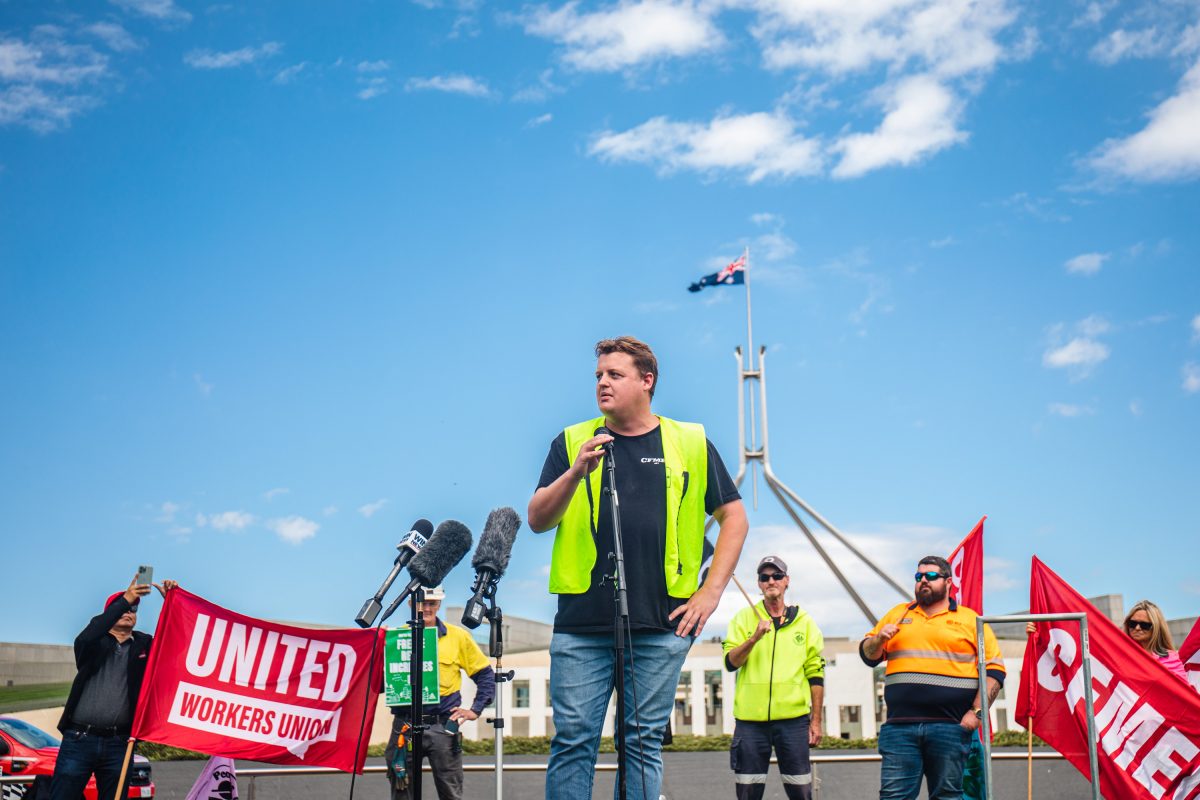union official in hi-viz giving a speech outside Parliament House